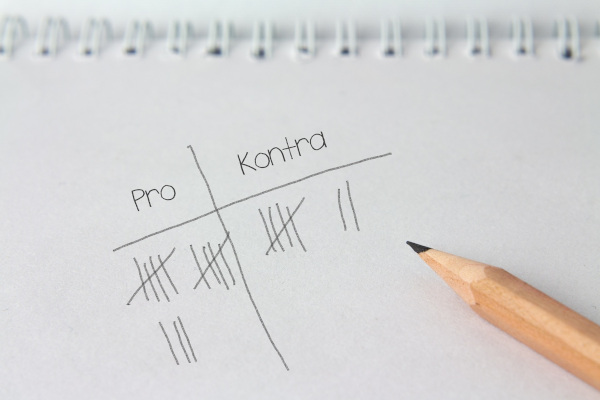 Schreibblock und Bleistift mit Pro- und Kontra-Liste