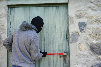 Einbrecher mit Brecheisen an einer T&uuml;r